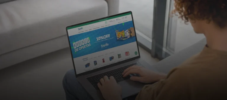 Pessoa usando notebook em casa, acessando o site da Suprijá em busca de ofertas.