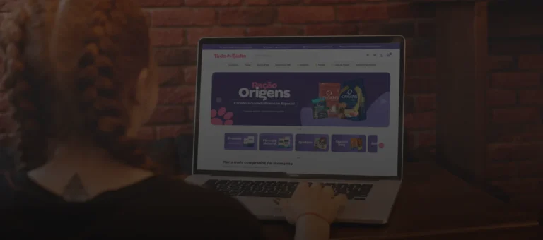 Imagem de uma mulher usando notebook em busca de produtos para o seu pet no site Tudo de Bicho.