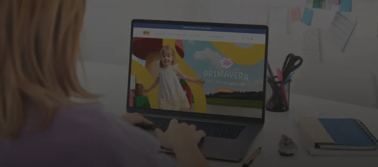 Imagem de mulher usando um notebook, buscando roupa infantil no site Kyly, para presentear uma criança