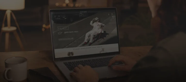 Imagem de mulher usando notebook sobre uma mesa, buscando roupas femininas na Haight.